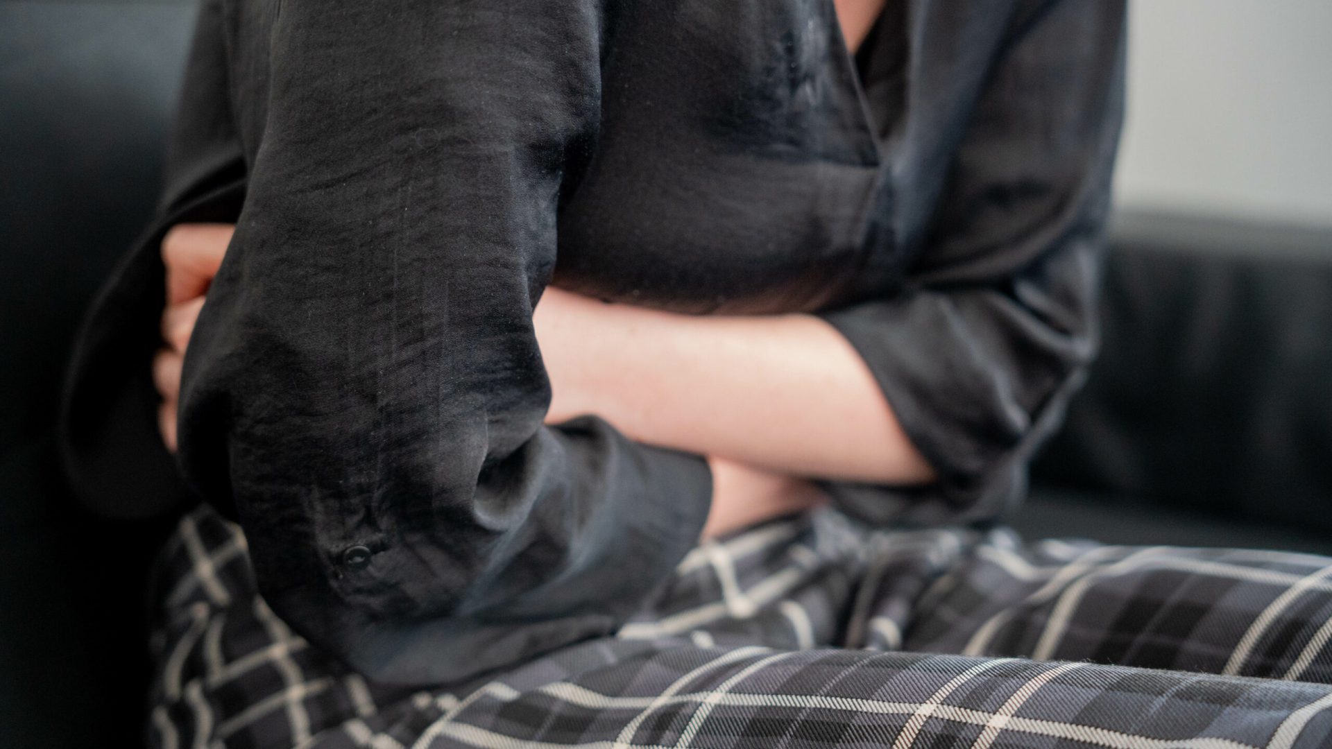 Photo d'une personne se tenant le ventre à cause de la douleur.